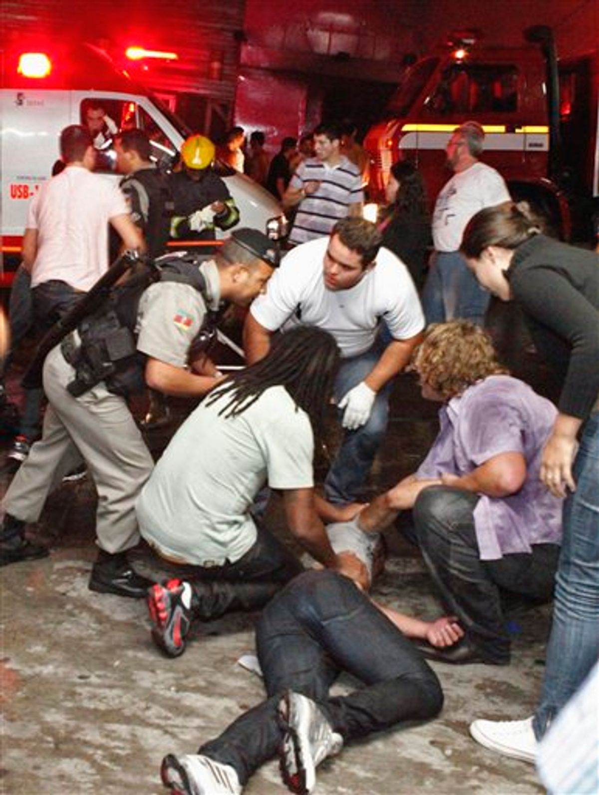 People help an injured man, victim of a fire in a club in Santa Maria city, Rio Grande do Sul state,  Brazil. (AP/Agencia RBS)  