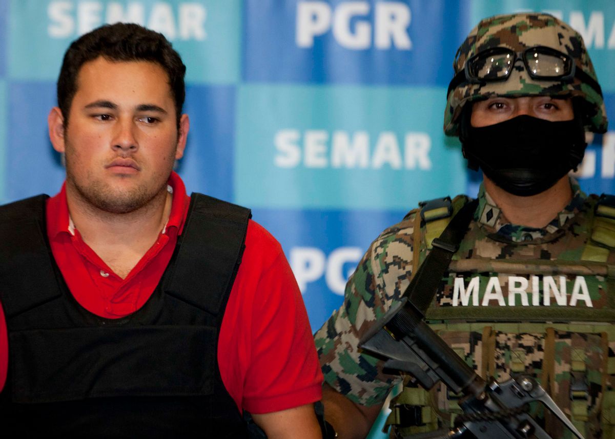 A Mexican marine escorts Jesus Alfredo Guzman Salazar, left, during his presentation to the media in Mexico City.                (AP/Eduardo Verdugo)