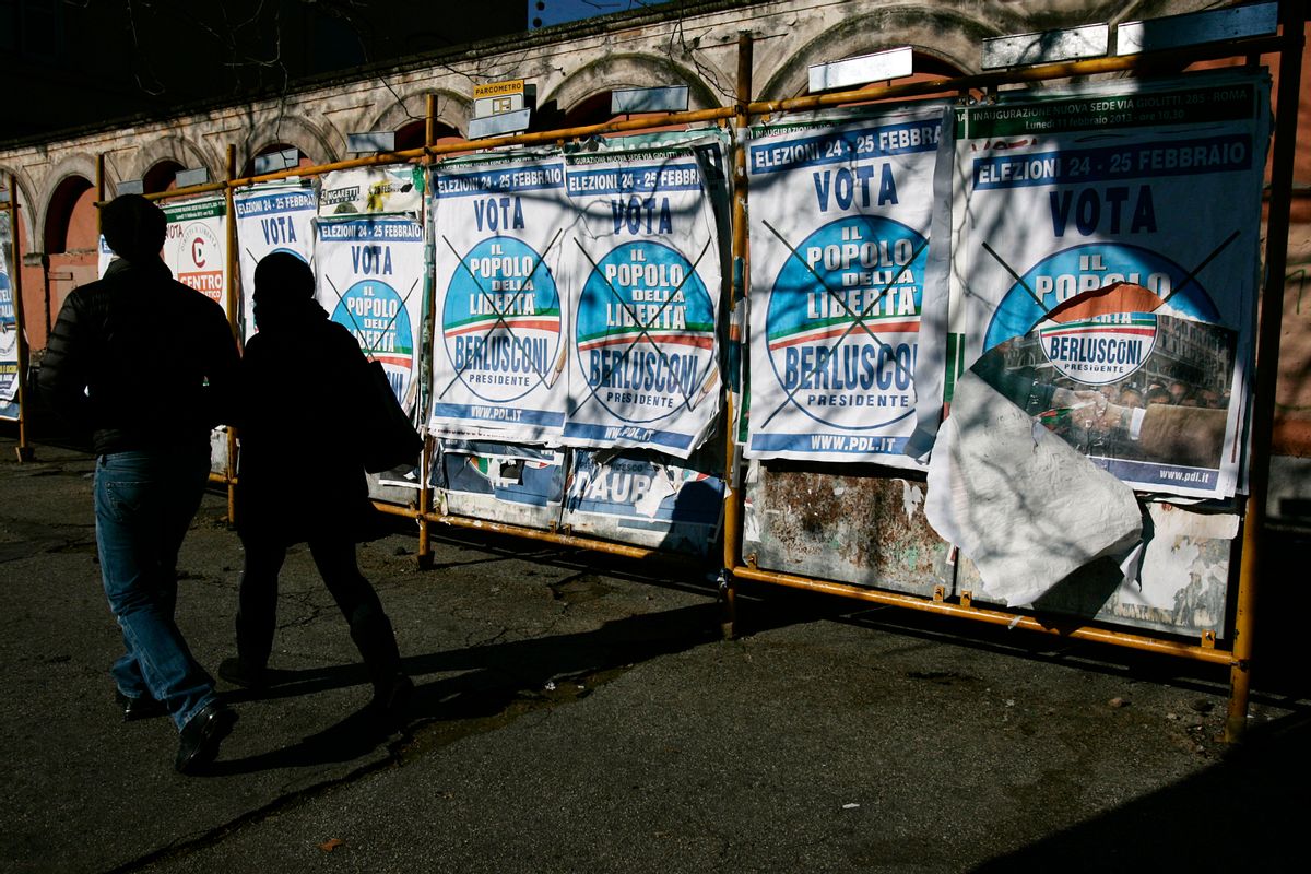 A couple walks past electoral posters of People of Freedom party reading: "February 24-25 Vote People of Freedom, Berlusconi for President", in Rome.    (AP/Gregorio Borgia)