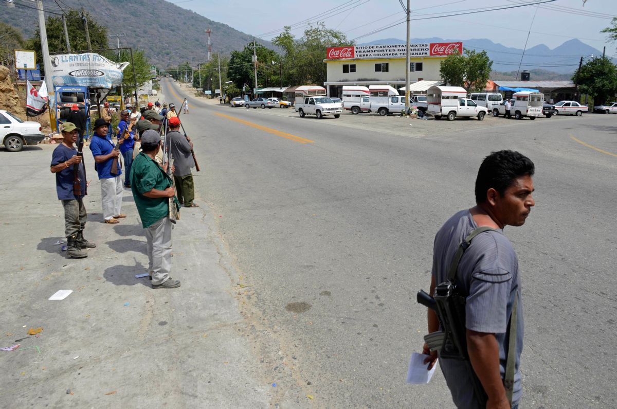 A group of armed vigilantes stand at the entrance to the town of Tierra Colorada, Mexico, Wednesday, March 27, 2013.    (AP/Bernandino Hernandez)