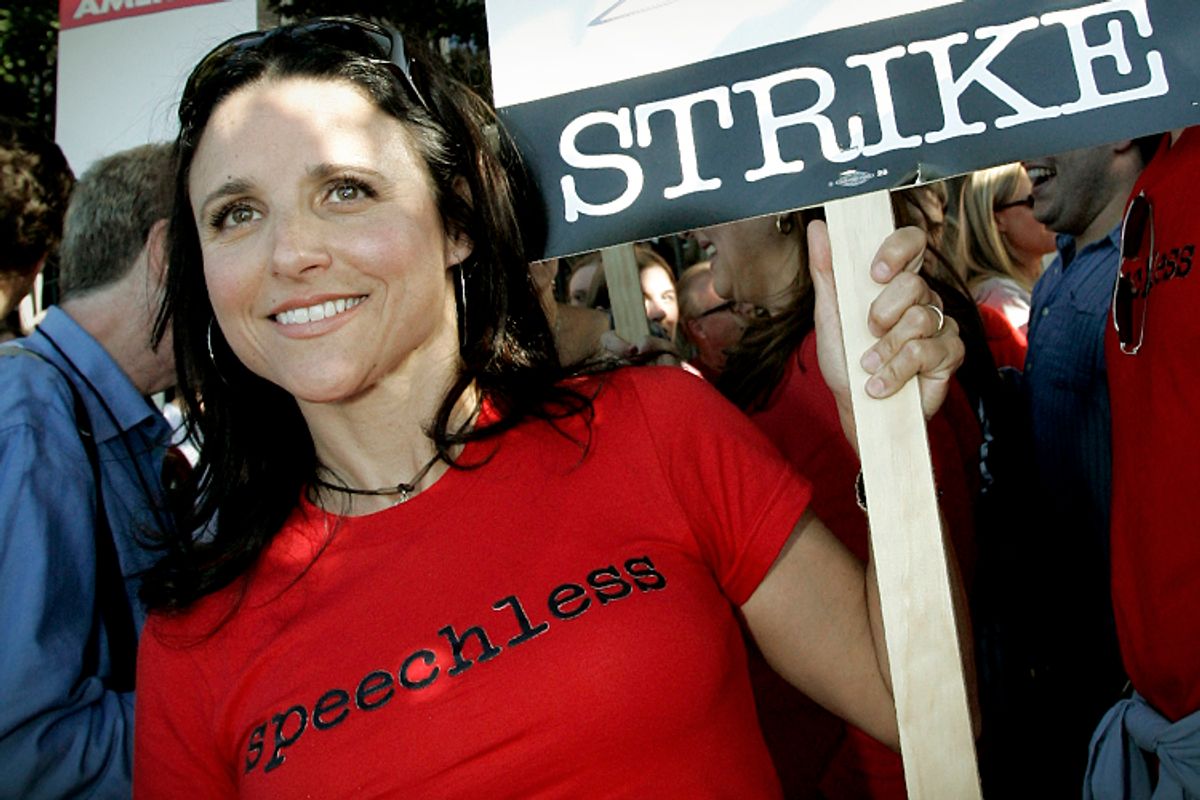 Screen Actors Guild (SAG) member Julia-Louis Dreyfus holds a strike sign  as she joins members of the Writers Guild of America (WGA) and others on the picket line.   (AP/Reed Saxon)