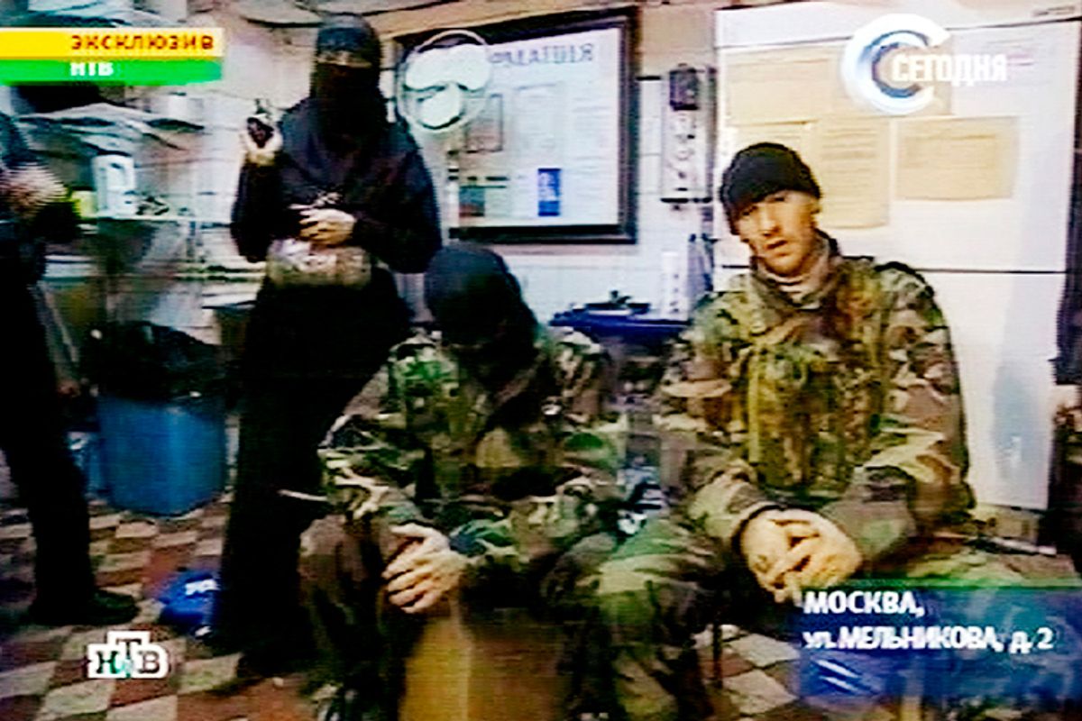 A man identified as Movsar Barayev, reported to be a leader of armed Chechens, who seized a crowded Moscow theater, right, is seen with another male captor, center, and a woman captor, left,  somewhere inside  the theater, Moscow, in this early Friday, Oct. 25, 2002 image from television by Russia's NTV.       (AP)