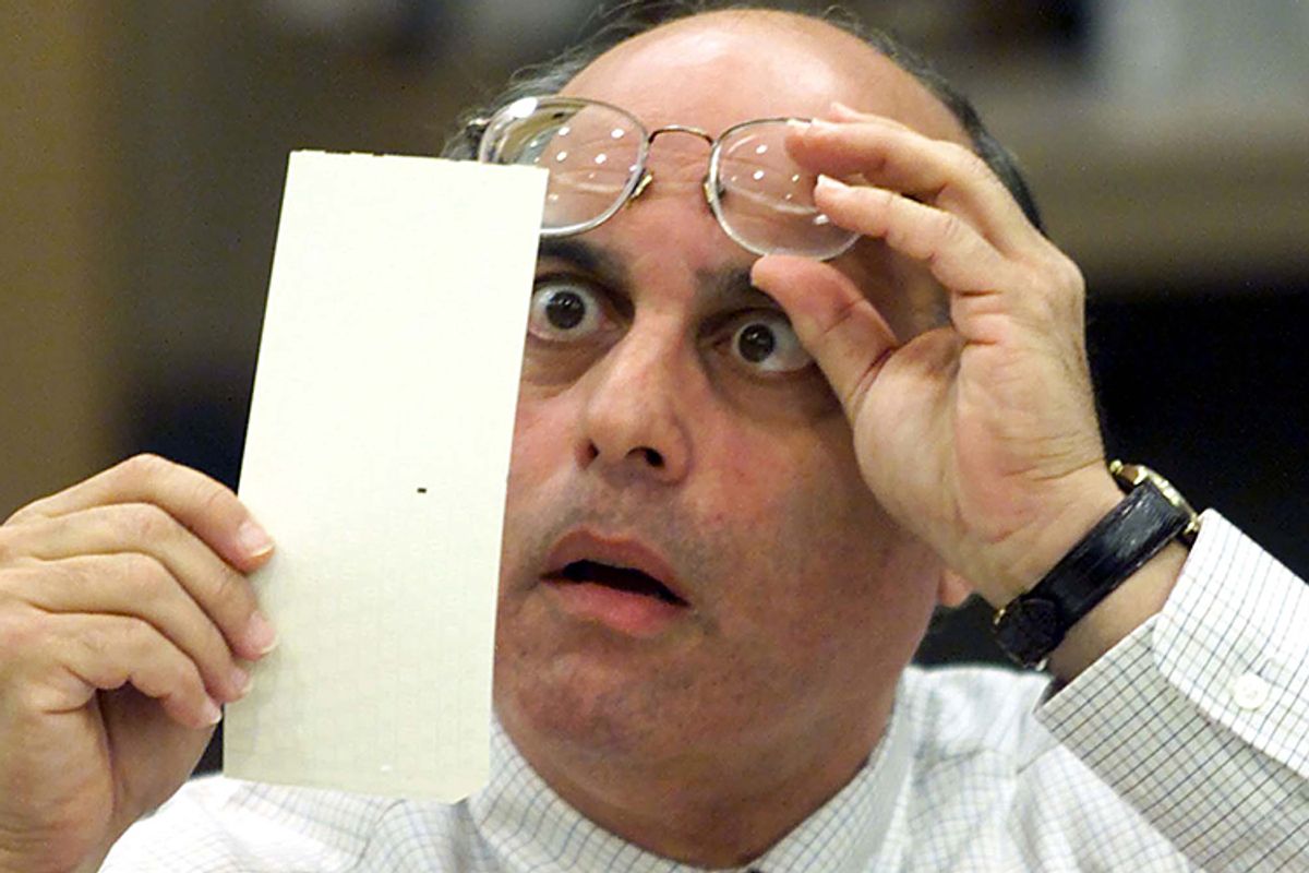 Broward County Canvassing Board member Judge Robert Rosenberg stares at a dimpled punchcard ballot November 23, 2000 during the recount of the 2000 presidential election.    (Reuters/Colin Braley)