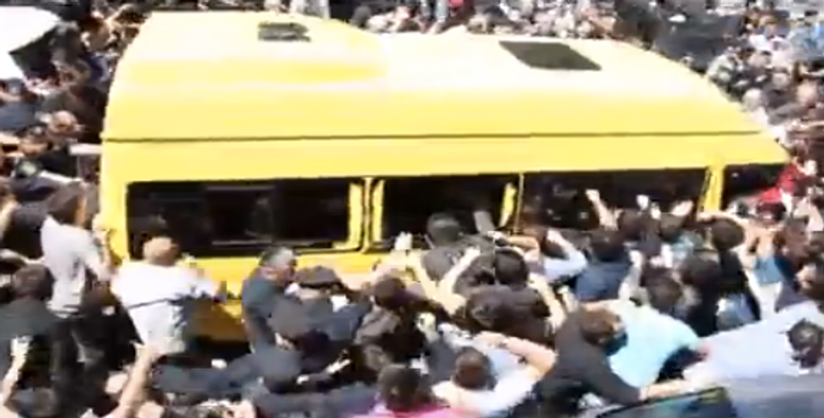 Violent protestors mob buses escorting gay rights marchers to safety.  (YouTube)