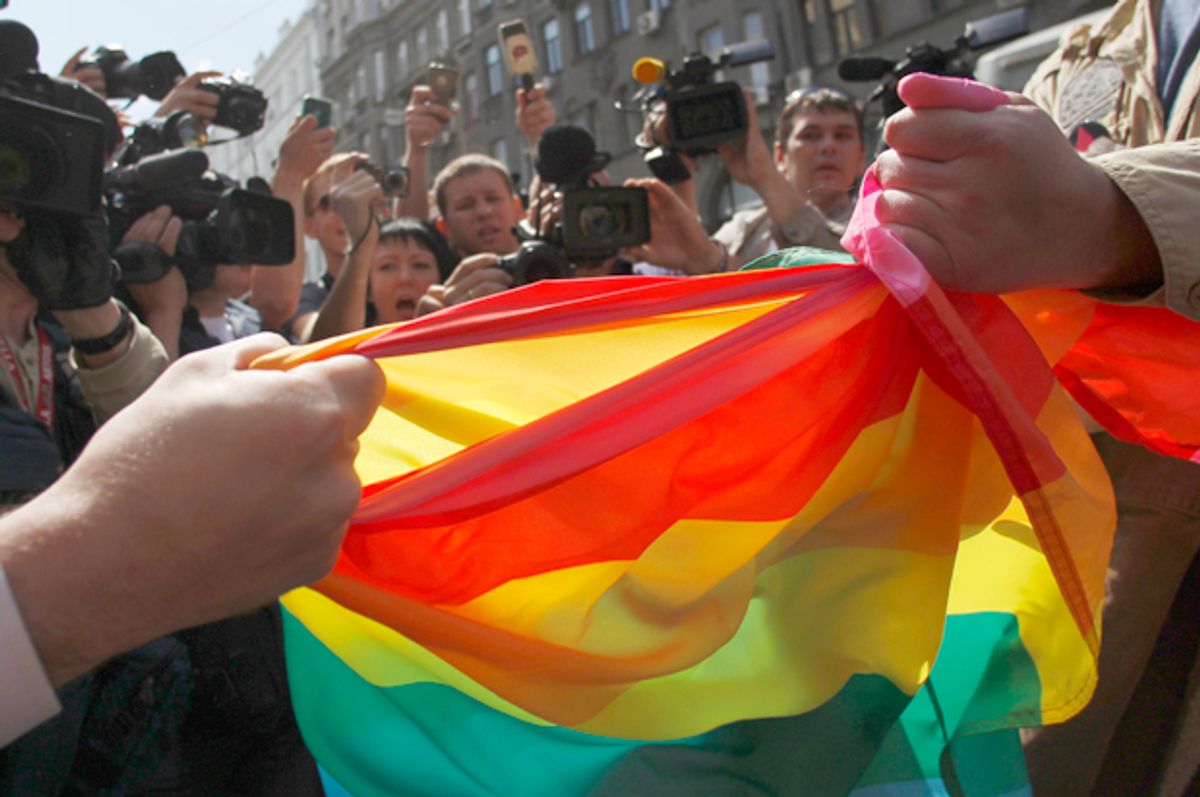 A man protesting a gay pride parade attempts to rip a gay rights activist's banner in Moscow, May 27, 2012.   (Reuters/Maxim Shemetov)