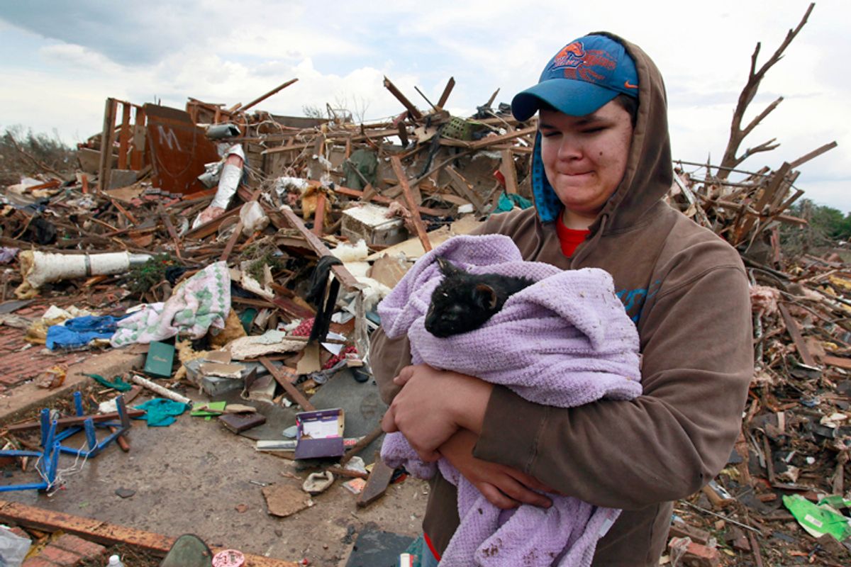 Austin Brock holds cat Tutti after the animal was retrieved from the rubble of Brock's home, which was demolished a day earlier in Moore, Okla., May 21, 2013.    (AP/Brennan Linsley)
