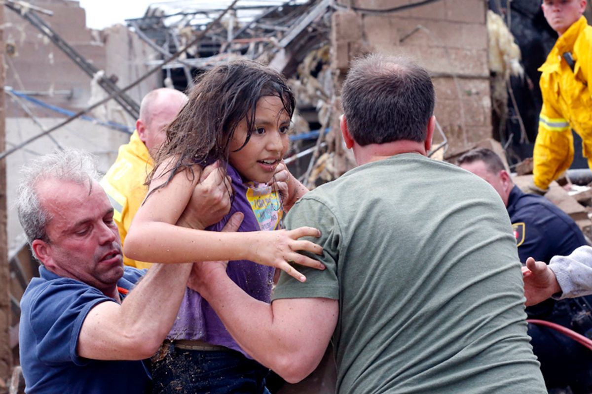 A child is pulled from the rubble of the Plaza Towers Elementary School in Moore, Okla., May 20, 2013.   (AP/Sue Ogrocki)