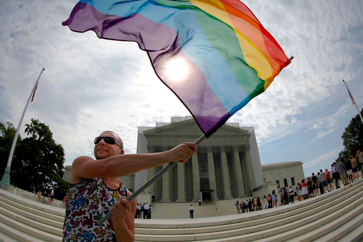 A gay marriage supporter waves a rainbow flag in anticipation of U.S. Supreme Court rulings, June 24, 2013.     (Reuters/Jonathan Ernst)