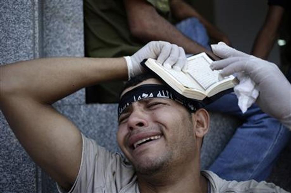 An Egyptian grieves for supporters of Egypt's ousted President Mohammed Morsi, who were killed in overnight clashes with security forces, at a field hospital in Nasr City, Cairo, Saturday, July 27, 2013. Clashes erupted early Saturday in Cairo between security forces and supporters of Morsi, killing scores of protesters and overwhelming field hospitals with the wounded. (AP Photo/Hassan Ammar)