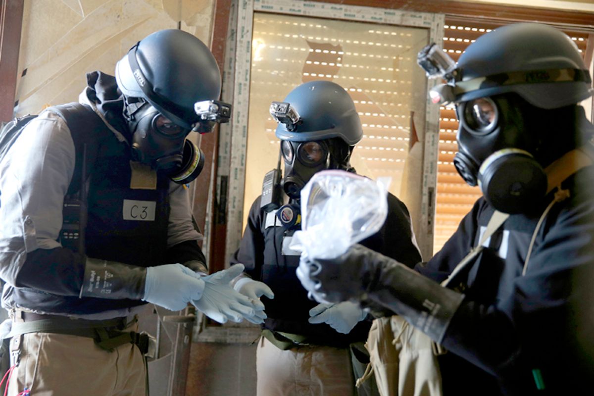 A U.N. chemical weapons expert, wearing a gas mask, holds a plastic bag containing samples from one of the sites of an alleged chemical weapons attack in the Ain Tarma neighbourhood of Damascus August 29, 2013.     (Mohamed Abdullah/Reuters)