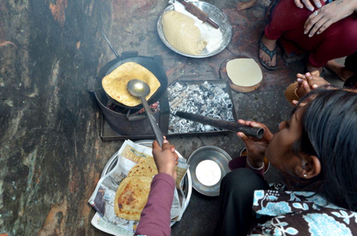 A woman cooking chapatis in oil to make pancakes, on February 4, 2013 in Delhi, India.     (africa924/Shutterstock)