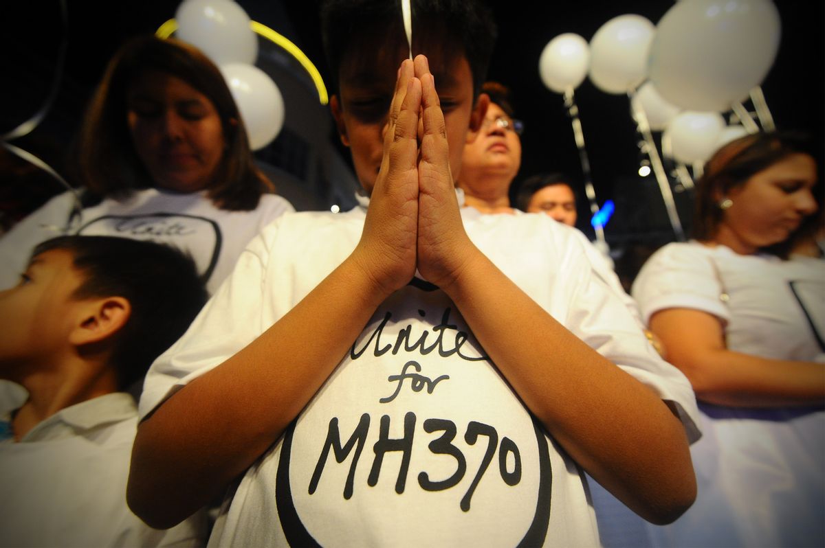 A young Malaysian boy prays, at an event for the missing Malaysia Airline, MH370, at a shopping mall, in Petaling Jaya,  on the outskirts of Kuala Lumpur, Malaysia, Tuesday, March 18, 2014.  A coalition of 26 countries, including Thailand, are looking for Malaysia Airlines Flight 370, which vanished March 8 with 239 people aboard on a night flight from Kuala Lumpur to Beijing. Search crews are scouring two giant arcs of territory amounting to the size of Australia  half of it in the remote seas of the southern Indian Ocean. (AP Photo/Joshua Paul) (AP)
