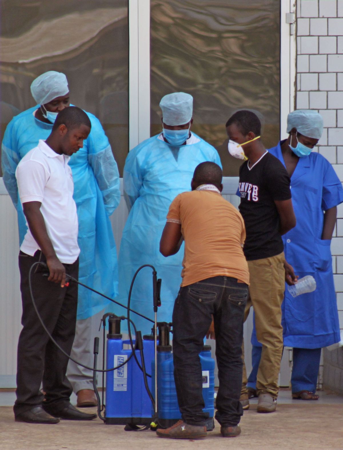In this photo taken on Saturday, March 29, 2014, medical personnel at the emergency entrance of a hospital receive suspected Ebola virus patients in Conakry, Guinea. (AP Photo/ Youssouf Bah)    