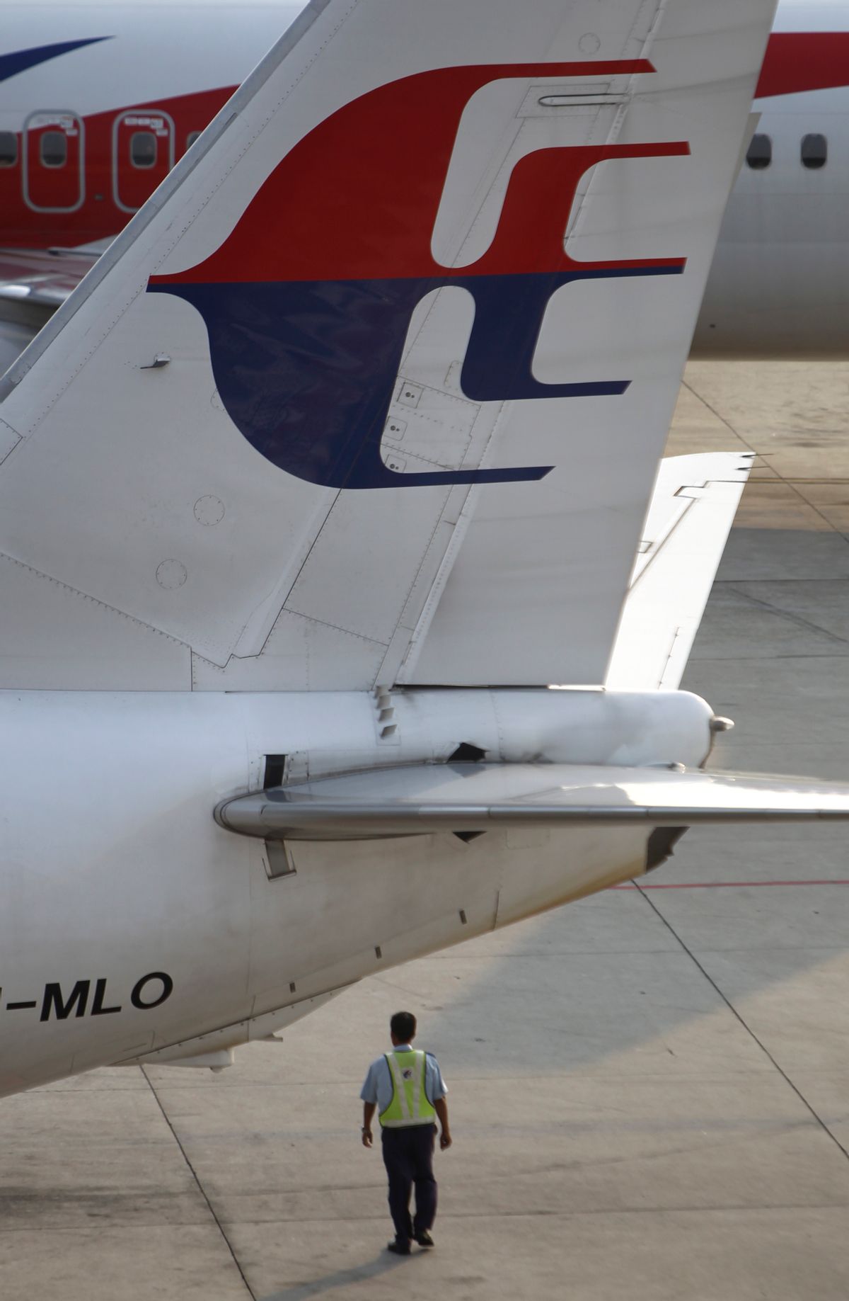 A ground staff member walks under a Malaysia Airlines plane at Kuala Lumpur International Airport in Sepang, Malaysia, Wednesday, March 12, 2014. The missing Malaysian jetliner may have attempted to turn back before it vanished from radar, but there is no evidence it reached the Strait of Malacca, Malaysia's air force chief said Wednesday, denying reported remarks he said otherwise. The statement suggested continued confusion over where the Boeing 777 might have ended up, more than four days after it disappeared en route to Beijing from Kuala Lumpur with 239 people on board. (AP Photo/Lai Seng Sin)    (AP)