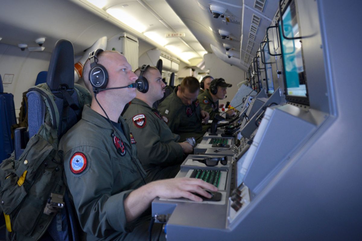 Crew members on board aircraft P-8A Poseidon assist in search and rescue operations for Malaysia Airlines flight MH370 in the Indian Ocean, March 16, 2014.      (AP/Eric A. Pastor)