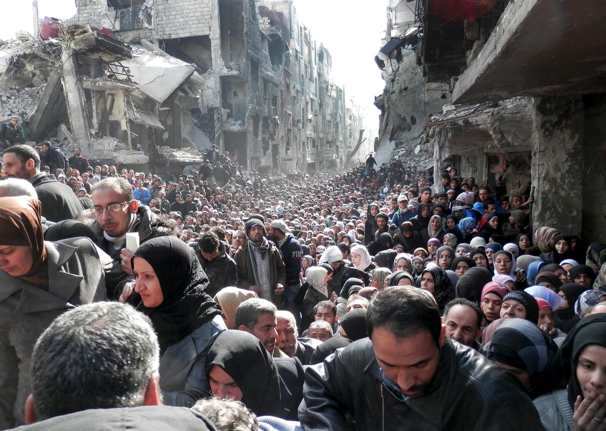 FILE -- In this Jan. 31, 2014, file photo, released by the United Nations Relief and Works Agency for Palestine Refugees in the Near East (UNRWA), shows residents of the besieged Palestinian camp of Yarmouk, queuing to receive food supplies, in Damascus, Syria. In one besieged neighborhood after another, weary rebels have turned over their weapons to the Syrian government in exchange for an easing of suffocating blockades that have prevented food, medicine and other staples from reaching civilians trapped inside. The government touts the truces as part of its program of national reconciliation to end Syrias crisis, which has killed more than 140,000 people since March 2011. (AP Photo/UNRWA, File) (AP)