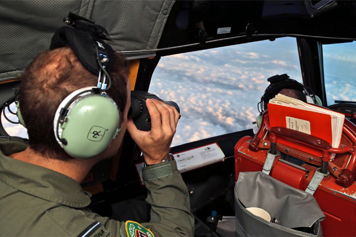 A crew member aboard a Royal Australian Air Force (RAAF) AP-3C Orion uses binoculars as it flies over the southern Indian Ocean during the search for missing Malaysian Airlines flight MH370. (Reuters/Rob Griffith)
