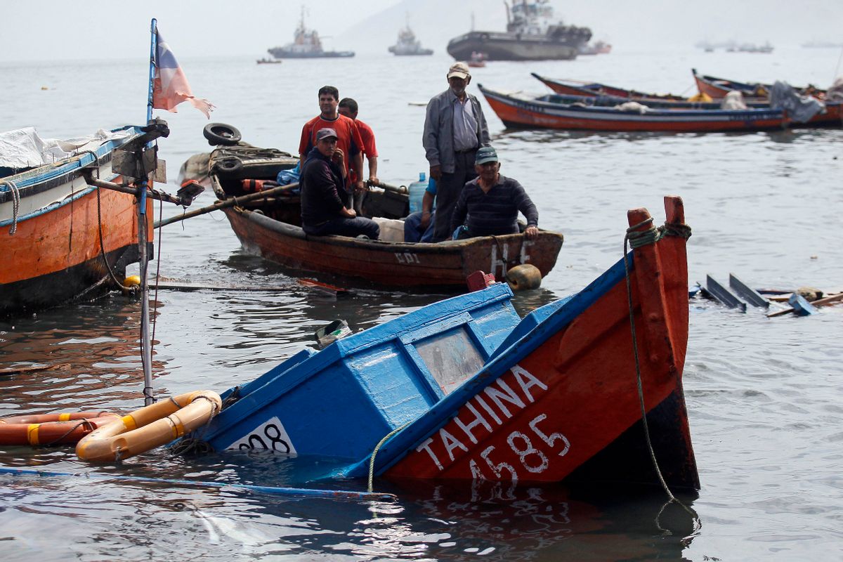 Fishermen look for boats to salvage damaged overnight in the port of Iquique, Chile, Wednesday, April 2, 2014. ( AP Photo/ Luis Hidalgo, Pool)  