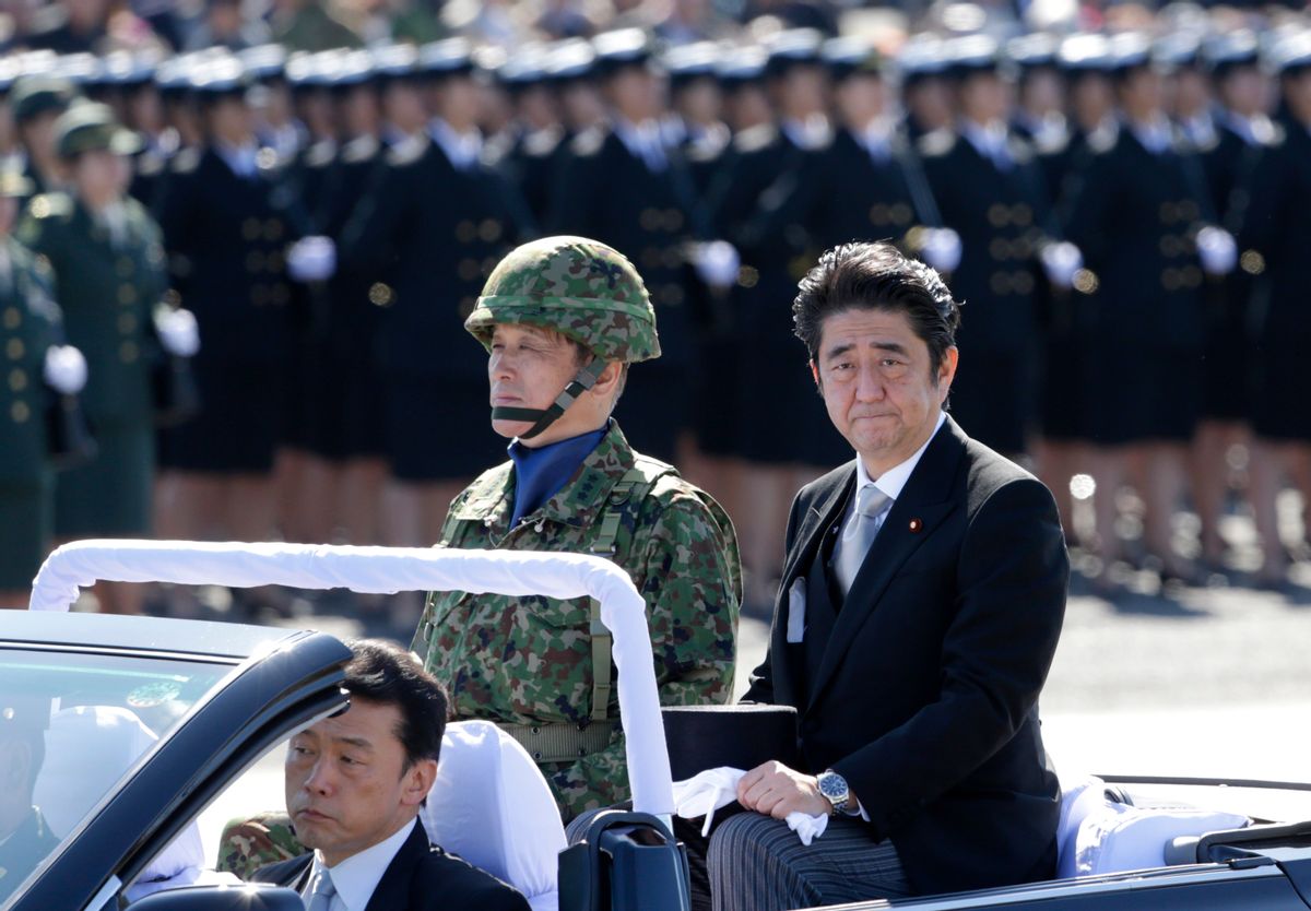 FILE - In this Sunday, Oct. 27, 2013 file photo, Japanese Prime Minister Shinzo Abe, right, reviews members of Japan Self-Defense Forces (SDF) during the Self-Defense Forces Day at Asaka Base, north of Tokyo. Japan relaxed a decades-old ban on military-related exports Tuesday, April 1, 2014, in a bid to expand joint arms development with allies and equipment sales to Southeast Asia and elsewhere. The new guidelines endorsed Tuesday by the Cabinet are part of Abe's push to bolster national security amid China's military expansion and North Korea's nuclear threat. (AP Photo/Shizuo Kambayashi, File) (AP)