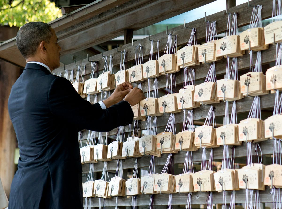 President Barack Obama places a prayer tablet on the Votive Tree as he tours the Meiji Shrine in Tokyo, Thursday, April 24, 2014. Opening a four-country swing through the Asia-Pacific region, Obama is aiming to promote the U.S. as a committed economic, military and political partner, but the West's dispute with Russia over Ukraine threatens to cast a shadow over the president's sales mission.(AP Photo/Carolyn Kaster) (Carolyn Kaster)