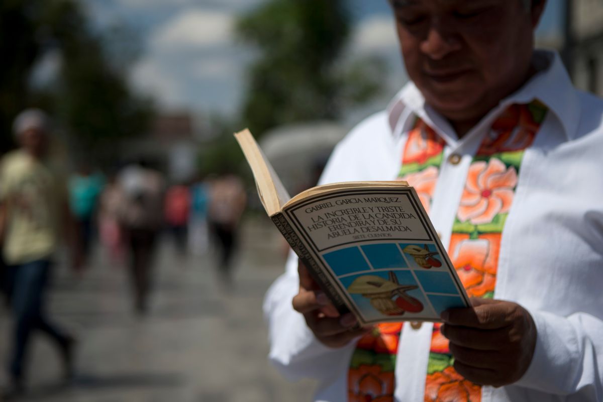 A man reads a book by Colombian Nobel Literature laureate Gabriel Garcia Marquez as he waits in line to pay his respects to the author at the Palace of Fine Arts in Mexico City, Monday, April 21, 2014. The ashes of  Garcia Marquez were taken Monday to Mexico City's majestic Palace of Fine Arts, where thousands of admiring readers began paying tribute to the Colombian Nobel laureate considered one of the greatest Spanish-language authors of all time.  (AP Photo/Rebecca Blackwell) (AP)