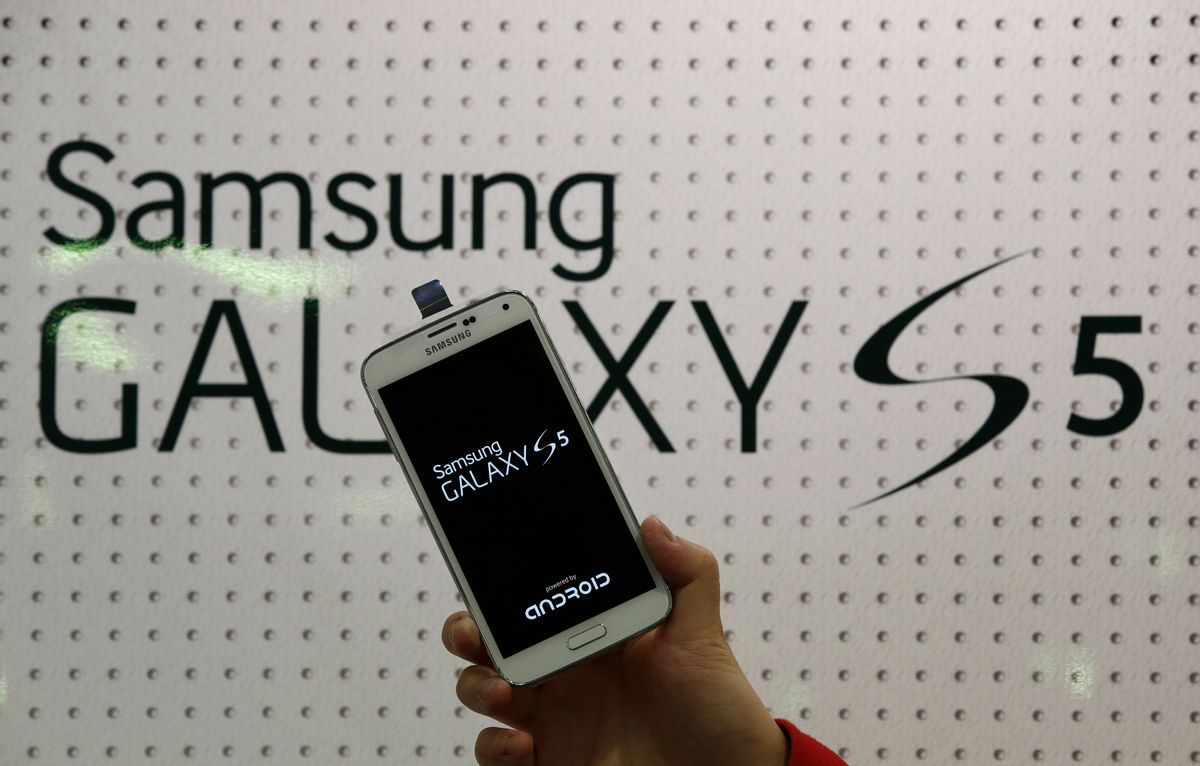An employee shows Samsung's Galaxy S5 smartphone at a mobile phone shop in Seoul, South Korea, Thursday, March 27, 2014. The global launch of Samsung's latest smartphone is being upstaged by South Korean mobile network companies. SK Telecom, South Korea's largest mobile carrier, said it will start selling the Galaxy S5 on Thursday, two weeks before the scheduled sales launch on April 11. (AP Photo/Lee Jin-man)  (Lee Jin-man)