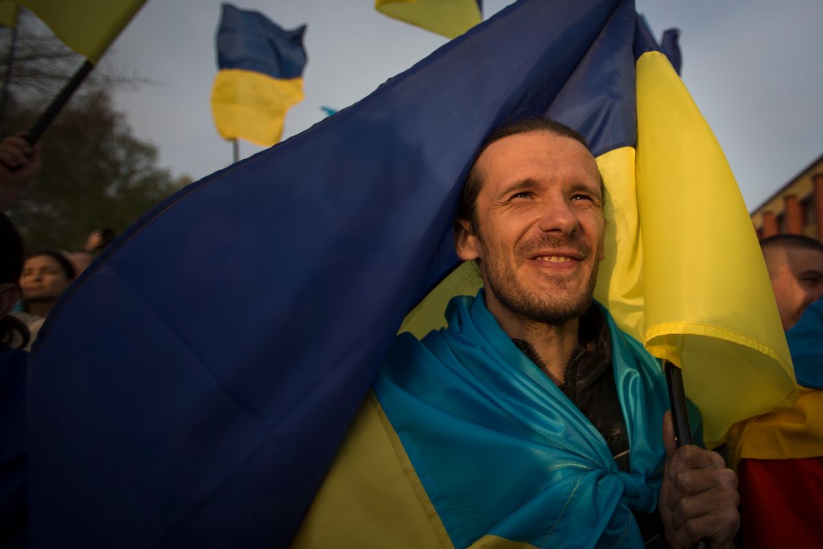 A man holds a Ukrainian national flag during a rally in support of a united Ukraine in Donetsk, Ukraine, Thursday, April 17, 2014. Defense Secretary Chuck Hagel says the U.S. will send nonlethal assistance to Ukraine's military in light of what he called Russia's ongoing destabilizing actions there. (AP Photo/Alexander Zemlianichenko) (AP)