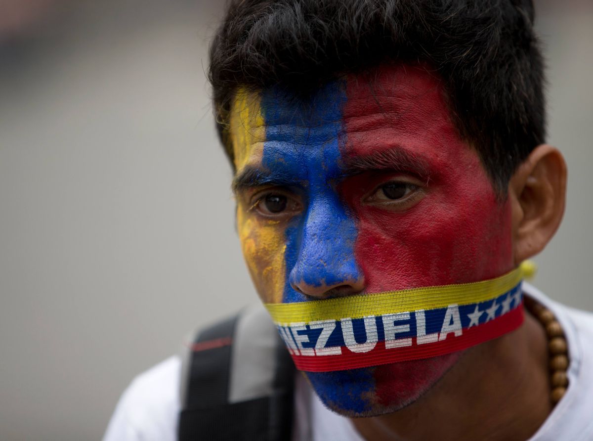 A man wears a narrow strip in the colors of Venezuela's flag over his mouth in protest of officials breaking up camps maintained by student protesters, in Caracas, Venezuela, Thursday, May 8, 2014. Hundreds of security forces broke up four camps maintained by student protesters, arresting more than 200 people in a pre-dawn raid. The camps of small tents were installed more than a month ago in front of the UN building and other anti-government strongholds in the capital to protest against President Nicolas Maduro's government. (AP Photo/Fernando Llano) (AP)
