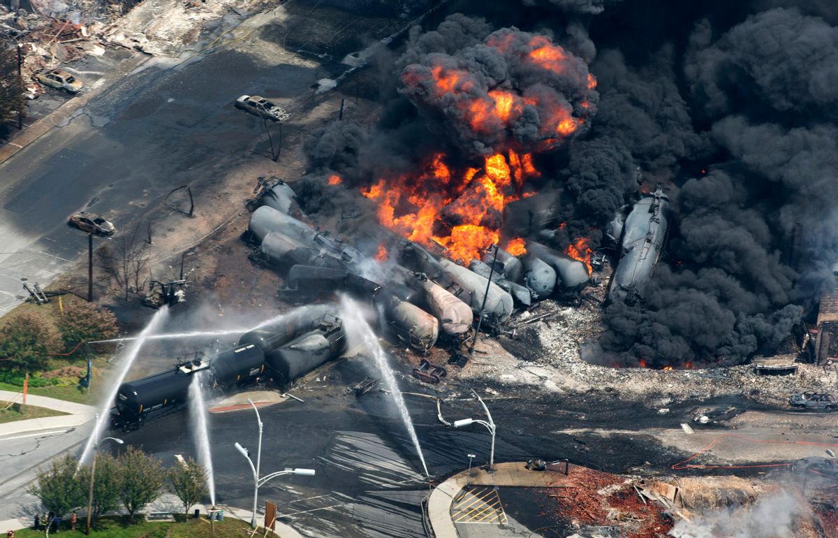 FILE - Smoke rises from railway cars that were carrying crude oil after derailing in downtown Lac Megantic, Quebec, Canada, Saturday, July 6, 2013.  Three employees and the railway company involved in the massive explosion, killing 47 people, will face criminal negligence charges, provincial prosecutors announced late Monday, May 12, 2014. (AP Photo/The Canadian Press, Paul Chiasson, File) (AP)