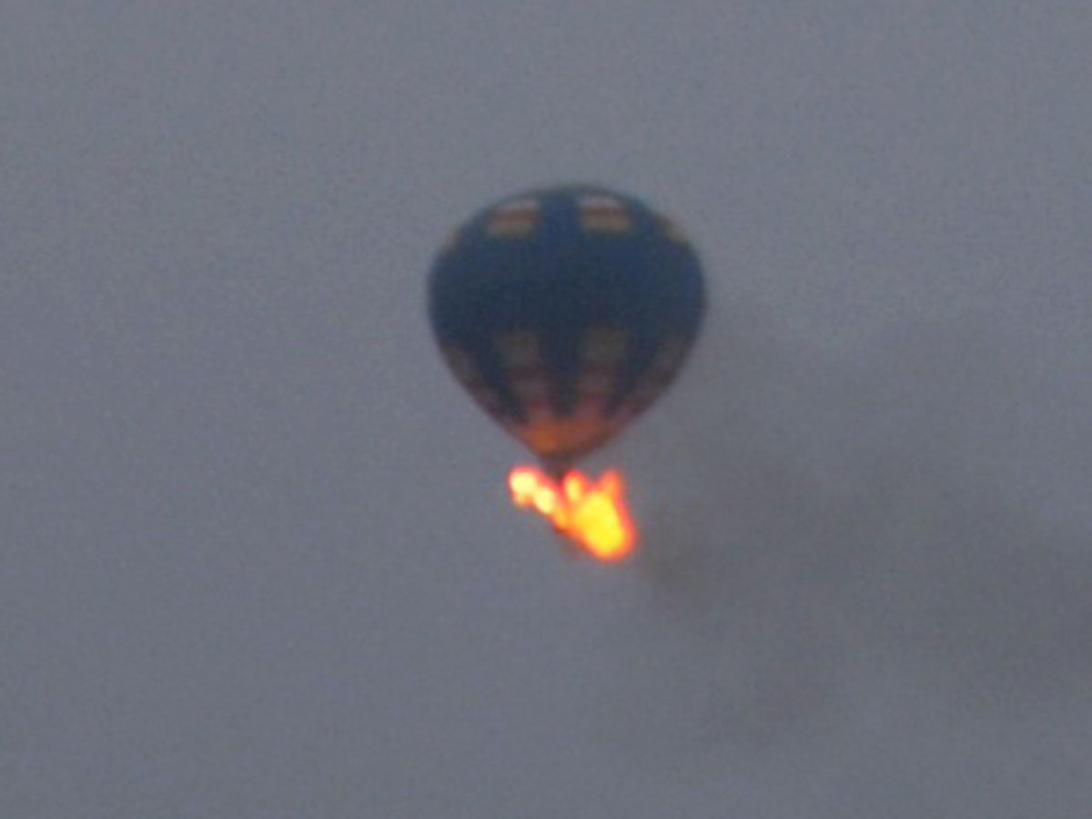 This photo provided by Nancy Johnson shows what authorities say is a hot-air balloon that was believed to have caught fire and crashed in Virginia, Friday, May 9, 2014. Virginia State Police received calls of the crash shortly before 8 p.m., police spokeswoman Corinne Geller told a news conference. Geller said a pilot and two passengers were believed to be on board, and that police believe it was the gondola that caught fire. (AP Photo/Nancy Johnson) (AP)