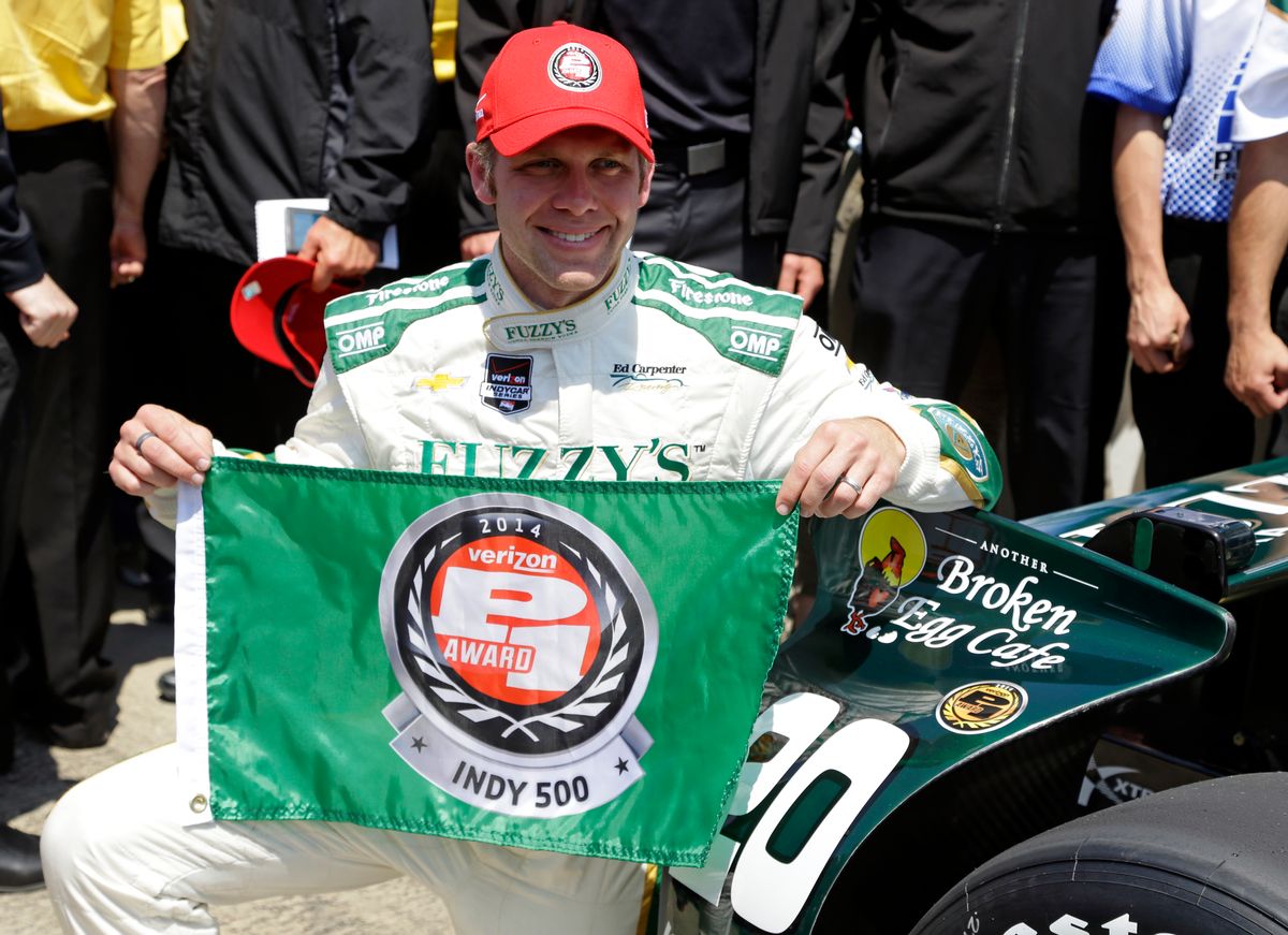 Ed Carpenter displays the P1 award flag after winning the pole during qualifications for the Indianapolis 500 IndyCar auto race at the Indianapolis Motor Speedway in Indianapolis, Sunday, May 18, 2014. (AP Photo/Michael Conroy) (AP)