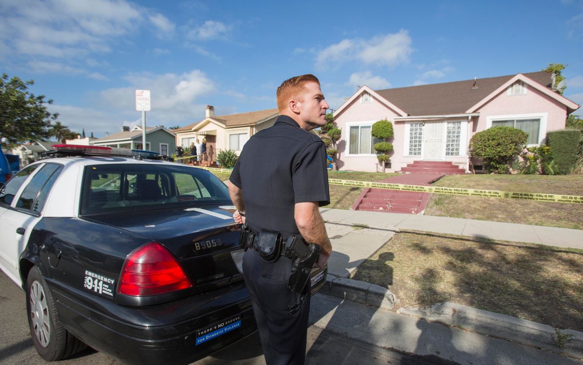 A police officer stands guard in front of the home of actor Michael Jace on Tuesday, May 20, 2014, in Los Angeles.  Jace, who played a police officer on the hit TV show "The Shield," was arrested on suspicion of homicide after his wife was found shot to death in their Los Angeles home, authorities said. Police arrived at the couple's home around 8:30 p.m. Monday after a report of shots fired, Officer Chris No said. April Jace, 40, was found dead inside, officials said.  Jace was taken into custody and booked early Tuesday on suspicion of homicide, No said. He was being held in a Los Angeles jail in lieu of $1 million bail.   (AP Photo/Ringo H.W. Chiu) (AP)