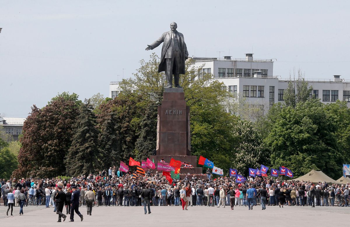 Ukrainians take part in a rally in front of a monument of Soviet revolutionary leader Vladimir Lenin, during a Victory Day celebration, which commemorates the 1945 defeat of Nazi Germany, in Kharkiv, Ukraine, Friday, May 9, 2014. Putin's surprise call on Wednesday for delaying the referendum in eastern Ukraine appeared to reflect Russia's desire to distance itself from the separatists as it bargains with the West over a settlement to the Ukrainian crisis. But insurgents in the Russian-speaking east defied Putin's call and said they would go ahead with the referendum. (AP Photo/Efrem Lukatsky) (AP)