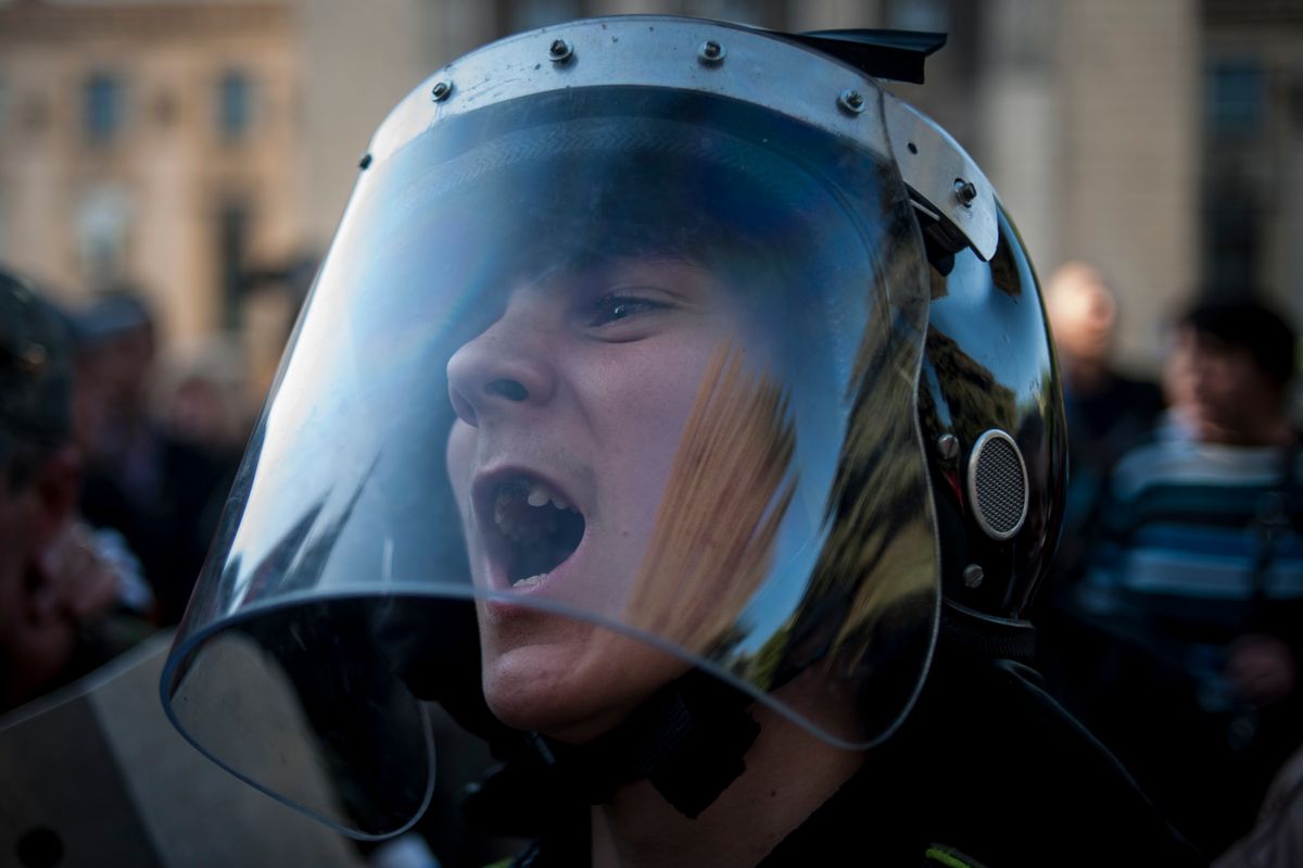 A pro-Russian activist wearing police helmet shouts outside the regional interior ministry building in Luhansk, eastern Ukraine, Wednesday, May 7, 2014. Eastern Ukraine has for weeks been swept by a wave of turbulent protests as opponents of the interim government in Kiev occupy official buildings and demand a referendum on autonomy for their regions. (AP Photo/Evgeniy Maloletka) (AP)