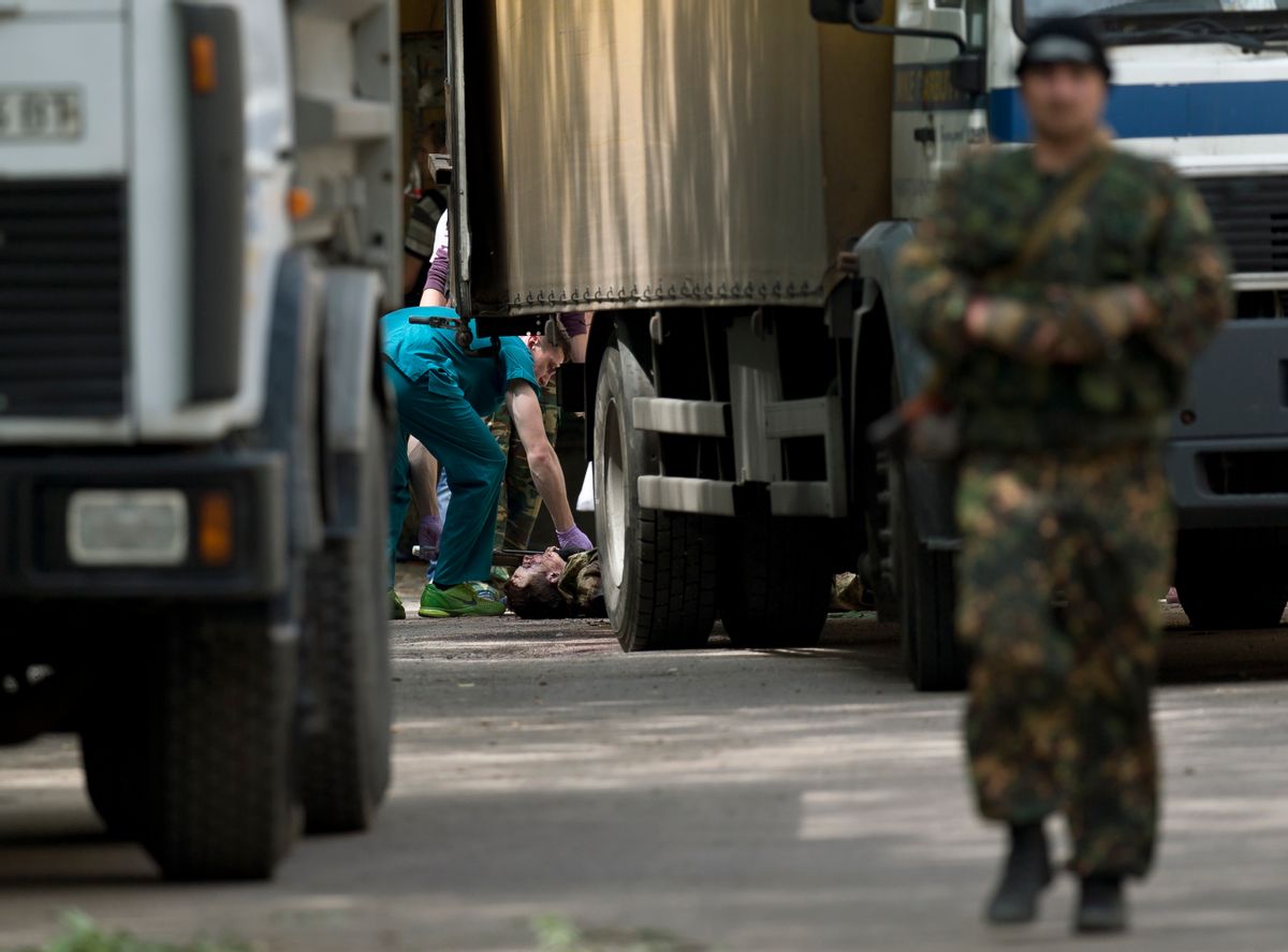 The body of a pro-Russian gunman killed during clashes with Ukrainian government forces around the airport lies on the pavement outside a city morgue in Donetsk, Ukraine, Tuesday, May 27, 2014. The eastern city of Donetsk was in turmoil Tuesday a day after government forces used fighter jets to stop pro-Russia separatists from taking over the airport. Dozens were reported killed and the mayor went on television to urge residents to stay indoors. (AP Photo/Vadim Ghirda) (AP)