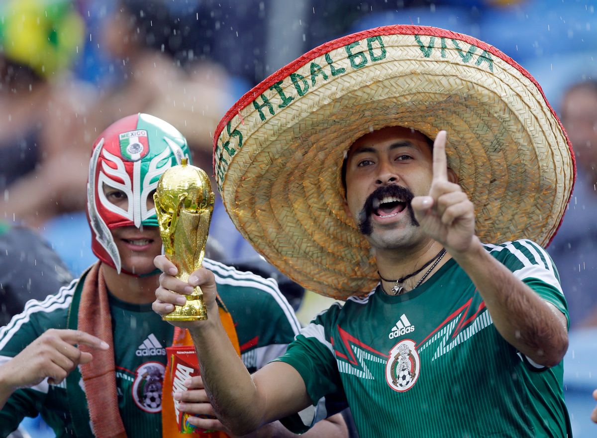 Mexican supporters gesture as they stand in  the rain before the soccer match between Mexico and Cameroon (AP/Ricardo Mazalan)