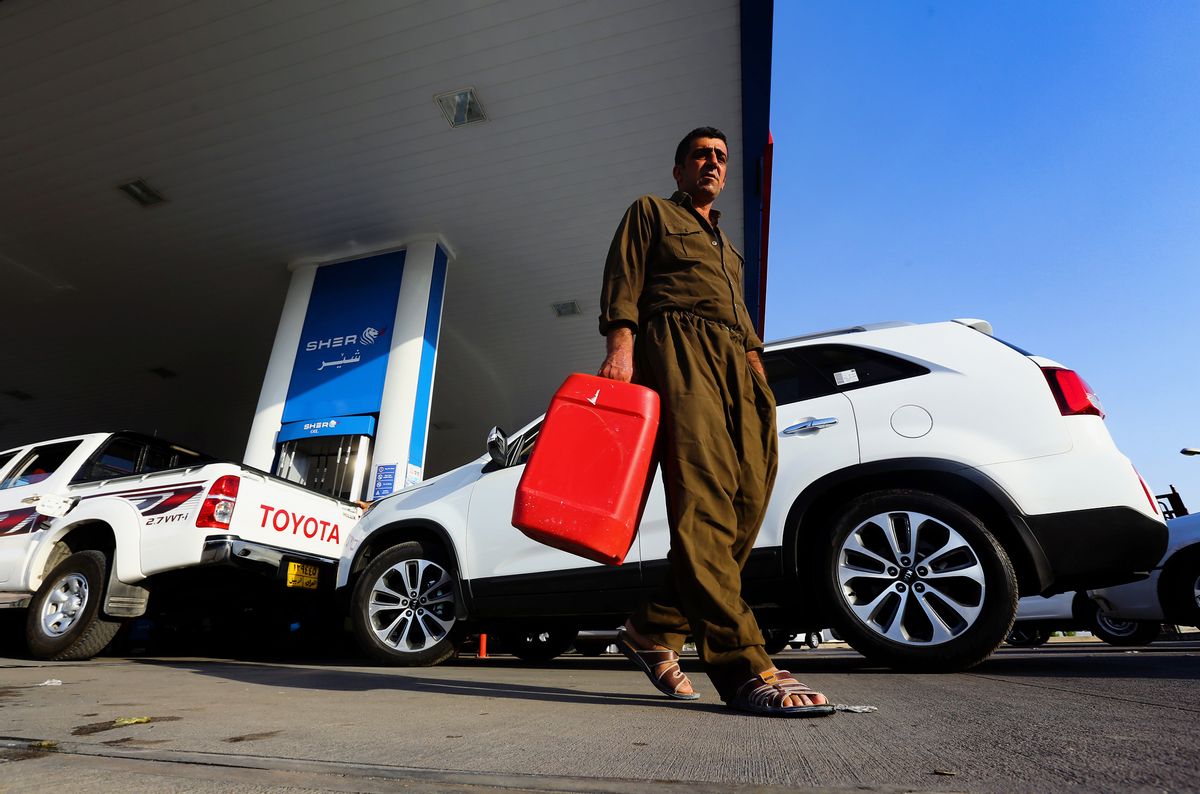 A man carries a fuel tank for gasoline at a gas station in Irbil, Iraq, Thursday, June 19, 2014. Iraqi soldiers and helicopter gunships appeared to be holding on after three days of battle against Sunni militants Thursday for control of Iraq's largest oil refinery, but Prime Minister Nouri al-Maliki's own fate seemed increasingly in play with political leaders meeting in recent days behind closed doors and discussing his future, according to a Shiite lawmaker. In Irbil, a city controlled by ethnic Kurds, lines stretched for miles at gas stations as angry motorists shouted at each other. (AP Photo) (AP)
