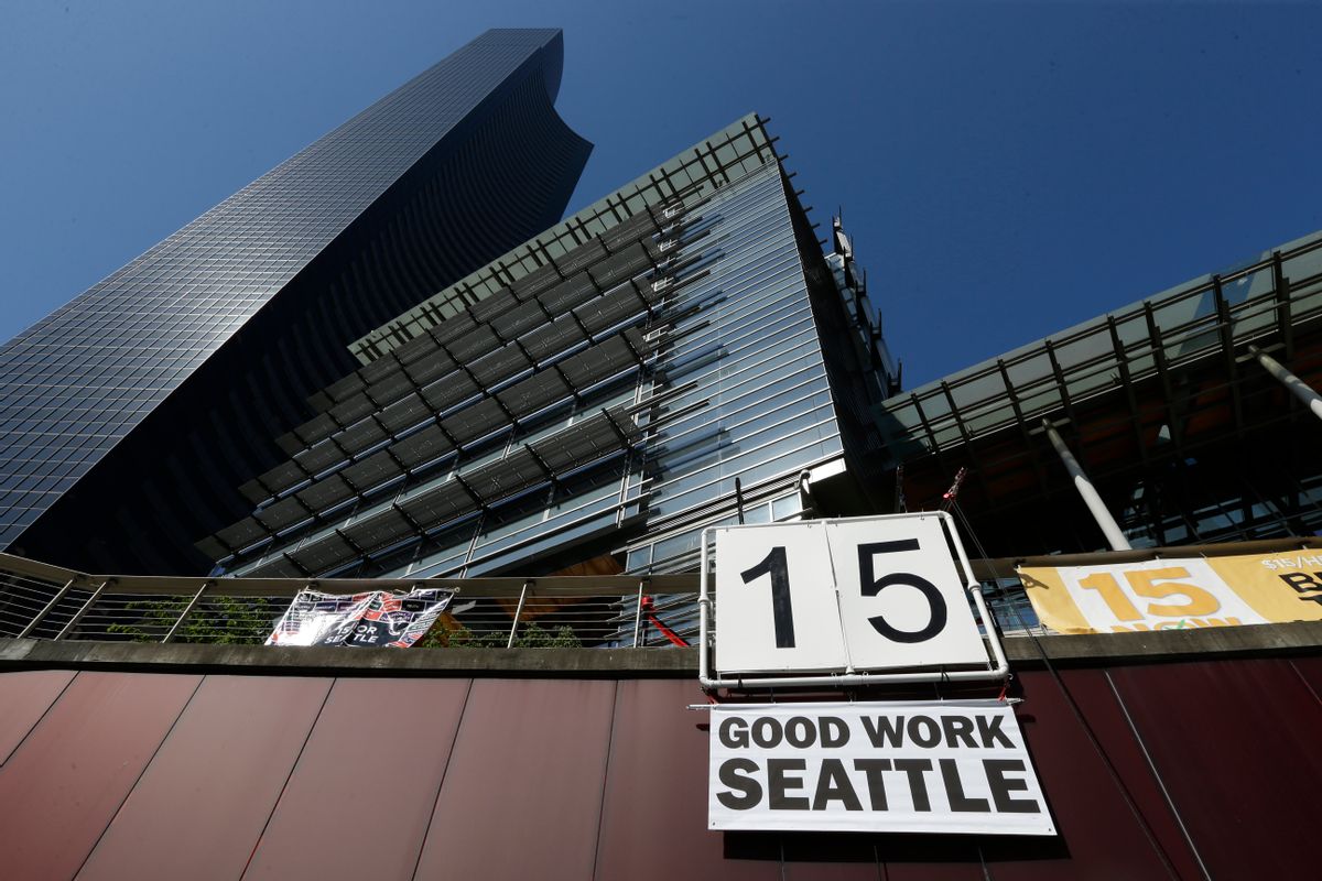 A sign that reads "15 Good Work Seattle" is displayed below Seattle City Hall, right, and the Columbia Center building, left, Monday, June 2, 2014, after the Seattle City Council passed a $15 minimum wage measure. (AP Photo/Ted S. Warren) (AP)