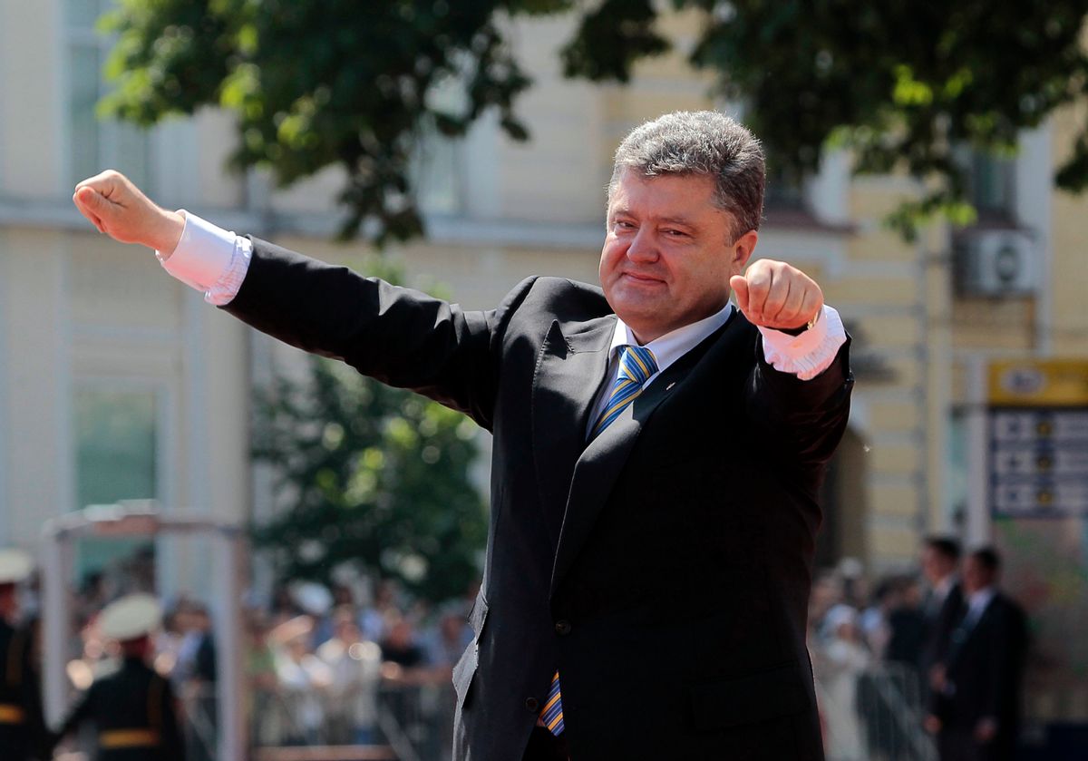 In this June 7, 2014, photo, Ukrainian President Petro Poroshenko lifts his arms in greeting after the inauguration ceremony in Sophia Square in Kiev, Ukraine. On paper, the Ukrainian trading firm known as Mistral dealt in management consulting and research, doing millions of dollars' worth of deals before going bust after Ukrainian President Viktor Yanukovych was chased out of office earlier this year. In the past five weeks authorities say they have shut at least 30 phony firms across the country, often raiding empty offices filled with bogus paperwork, fake corporate letterhead, and bundles of cash. But there have been no mass firings at the tax ministry. (AP Photo/Sergei Chuzavkov) (AP)