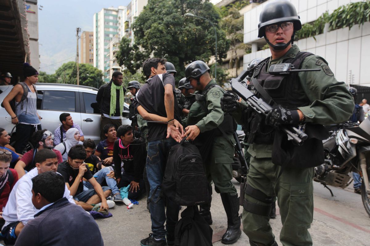 An anti-government demonstrator is handcuffed after he and others where detained by the Bolivarian National Guard, during clashes at a protest in Caracas, Venezuela, Wednesday, May 14, 2014.       (AP/Fernando Llano)