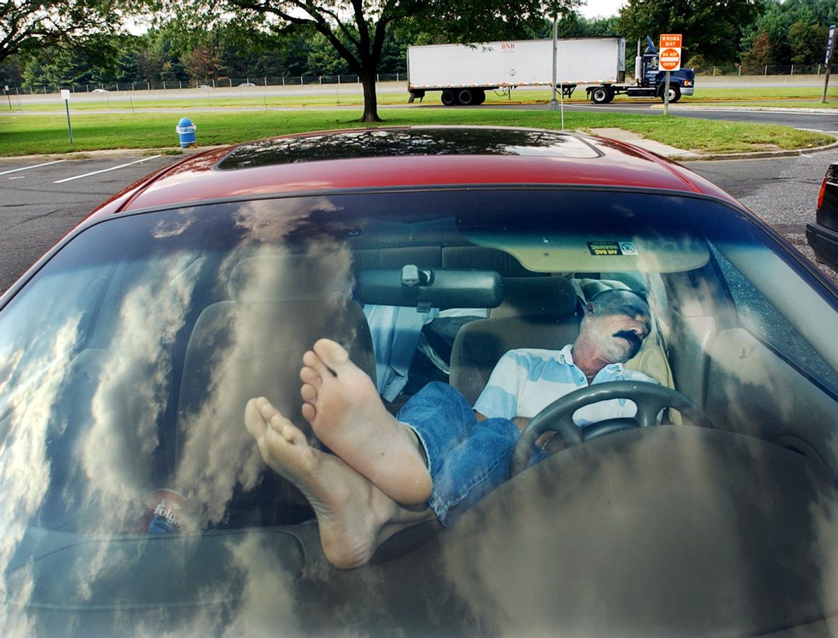 FILE - In this Sept. 25, 2003 file photo, an unidentified man rests his feet on the dashboard as he takes nap at a New Jersey Turnpike rest stop in Mount Laurel, N.J. The Centers for Disease Control and Prevention released its latest drowsy driving report on Thursday, July 3, 2014. According to a new survey, about 1 in 25 adults say they recently fell asleep while driving. (AP Photo/Daniel Hulshizer, File) (AP)