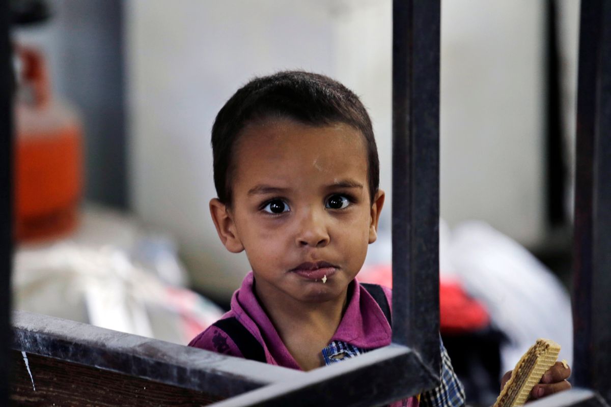 A displaced Palestinian boy, still inside a classroom, eats a snack at the Abu Hussein U.N. school in Jebaliya refugee camp. Some 3,300 Gazans seeking shelter from the fighting had been crowded into the U.N. school in Jebaliya refugee camp when it was hit by a series of Israeli artillery shells. (Associated Press/Lefteris Pitarakis)