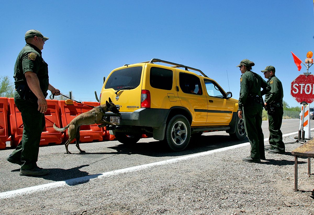 U.S. Border Patrol Senior Agent B.T. Hick and his dog Mirza, left, inspect a car at a check point outside Organ Pipe Cactus National Park in Why, Ariz., Wednesday, May 24, 2006. The detention of a prominent immigration activist at a Texas airport served as a reminder of the latitude the Border Patrol has in conducting checkpoints for drugs and immigrants in the country illegally at locations not on the border. (AP Photo/Matt York, File) (AP)