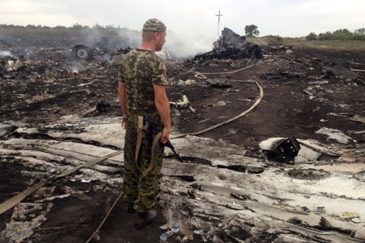An armed pro-Russian separatist stands at a site of a Malaysia Airlines Boeing 777 plane crash in the settlement of Grabovo in the Donetsk region, July 17, 2014.           (Reuters/Maxim Zmeyev)