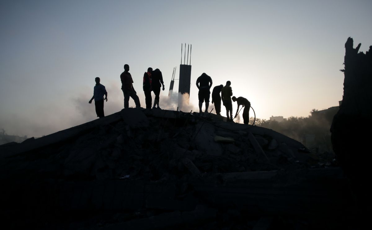 Palestinians try to salvage what they can of their belongings from the rubble of a house destroyed by an overnight Israeli airstrike in Gaza City Tuesday, July 8, 2014. Israel launched what could be a long-term offensive against the Hamas-ruled Gaza Strip on Tuesday, the military said, striking at least 50 sites in Gaza by air and sea and mobilizing troops for a possible ground invasion in order to quell rocket attacks on Israel. (AP Photo/Khalil Hamra) (AP)