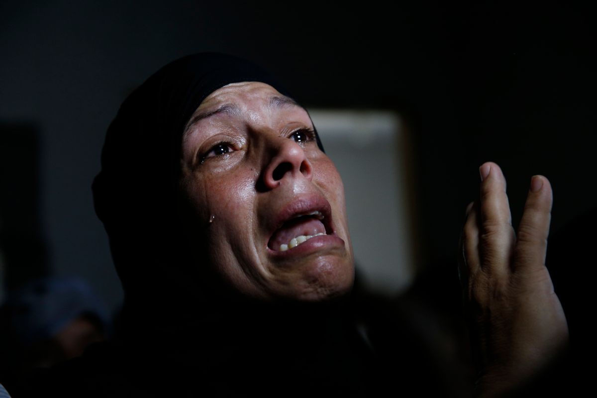 A Palestinian mourner cries in a house after the bodies of Mousa Abu Muamer, 56, and his son Saddam, 27, who were killed in an overnight Israeli missile strike at their house in the outskirts of the town of Khan Younis, southern Gaza Strip, were brought in for their funeral, Monday, July 14, 2014. Saddam's wife, Hanadi, 27, was also killed in the attack. (AP Photo/Lefteris Pitarakis) (AP)