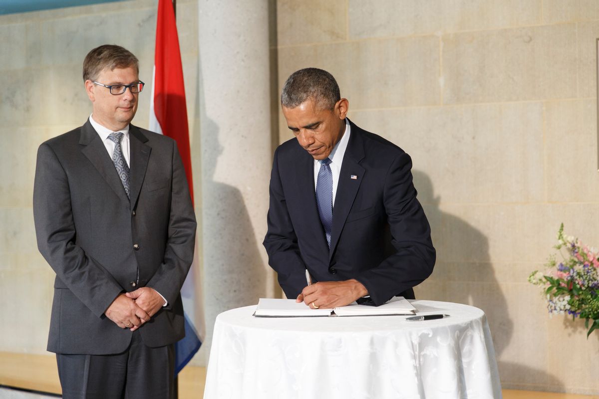 President Barack Obama visits the Dutch Embassy in Washington to sign a book of condolence, joined by Deputy Chief of Mission Peter Mollema, Tuesday, July 22, 2014. Most of the 298 people aboard the Malaysia Airlines plane that was shot down near the border between Ukraine and Russia were Dutch citizens. (AP Photo/J. Scott Applewhite) (AP)