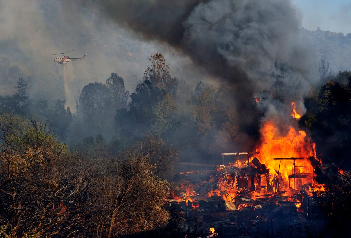 A structure burns along Highway 41 in Oakhurst, Calif., Monday, Aug. 18, 2014. One of several wildfires burning across California prompted the evacuation of hundreds of people in a central California foothill community near Yosemite National Park, authorities said.   (AP/The Fresno Bee, Eric Paul Zamora)