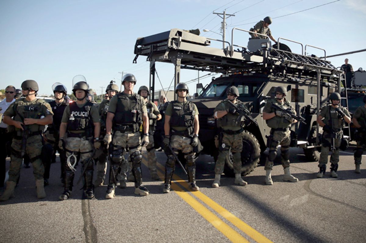 Police in riot gear watch protesters in Ferguson, Mo., Aug. 13, 2014.                      (AP/Jeff Roberson)