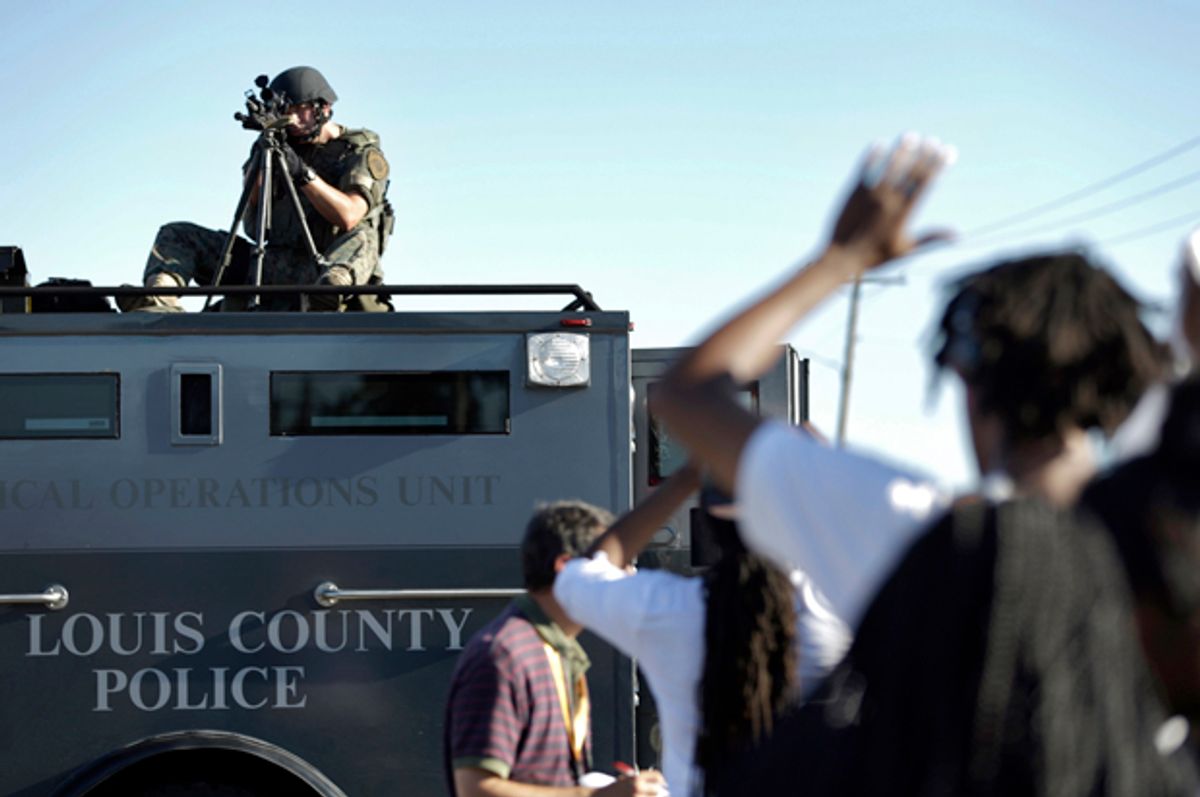 A member of the St. Louis County Police Department points his weapon in the direction of a group of protesters in Ferguson, Mo., Aug. 13, 2014.                       (AP/Jeff Roberson)